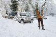 Photo: Woman standing in snow near car talking on cell phone Woman standing in snow near car talking on cell phone