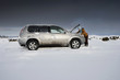 Photo: Woman standing in snow checking underneath carճ hood Woman standing in snow checking underneath carճ hood