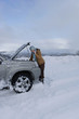 Photo: Woman standing in snow checking underneath carճ hood talking on cell phone Woman standing in snow checking underneath carճ hood talking on cell phone
