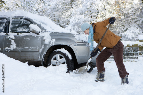 Photo: Woman shoveling snow near car Woman shoveling snow near car