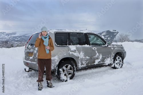 Photo: Woman standing in snow having car trouble talking on cell phone Woman standing in snow having car trouble talking on cell phone