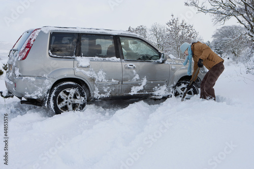 Photo: Woman shoveling snow near car Woman shoveling snow near car