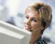 Smiling businesswoman in headset working at computer