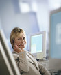 Smiling businesswoman in headset sitting at desk