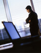 Photo: Businessman with arms crossed looking out office window Businessman with arms crossed looking out office window