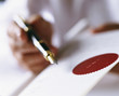 Close up of businessman holding fountain pen and paper with red seal