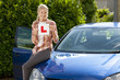 Photo: Portrait of smiling young woman holding learnerճ permit sticker on hood of car Portrait of smiling young woman holding learnerճ permit sticker on hood of car