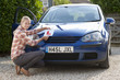 Photo: Portrait of smiling young woman attaching learnerճ permit sticker to hood of car Portrait of smiling young woman attaching learnerճ permit sticker to hood of car