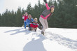 Happy family sledding in snow