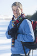 Portrait of smiling man with backpack in snow