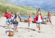 Family playing soccer on sunny beach