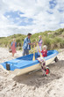 Family with paddles and boat on beach