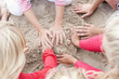 Hands of kids making sandcastle on beach