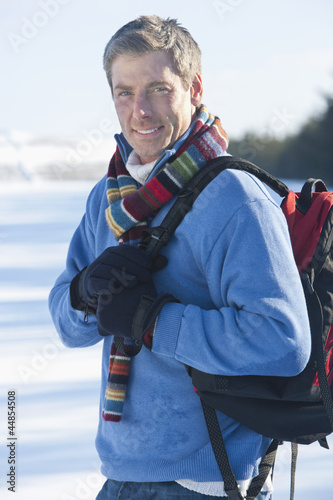 Photo: Portrait of smiling man with backpack in snow Portrait of smiling man with backpack in snow