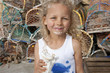 Portrait of smiling girl with ice cream on face in front of lobster traps