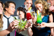 People in club or bar drinking cocktails