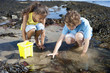 Boy and girl fishing in tide pool
