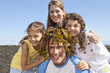 Family hugging man with seaweed on head