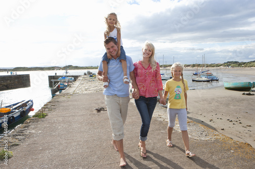 Photo: Portrait of smiling family walking along harbor Portrait of smiling family walking along harbor
