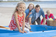Portrait of smiling family in boat on beach