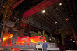 Engineers watching molten forged steel in furnace
