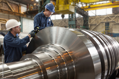Photo: Engineers working on metal machinery Engineers working on metal machinery