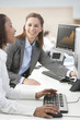 Photo: Smiling businesswomen working at computers in office Smiling businesswomen working at computers in office