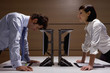 Businesswoman watching businessman lean on computer in office