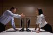 Businessman extending handshake to businesswoman in computer