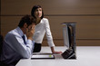 Worried businessman and businesswoman working at desk in office