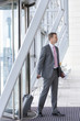 Photo : Businessman with passport and suitcase arriving at airport Businessman with passport and suitcase arriving at airport