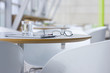 Digital tablet, eyeglasses and water on table