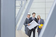 Architects and engineer holding blueprints in office