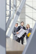 Architects and engineer holding blueprints in office