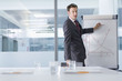 Photo: Portrait of businessman in suit pointing to graph in conference room Portrait of businessman in suit pointing to graph in conference room