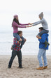 Young couples in piggyback battle on beach