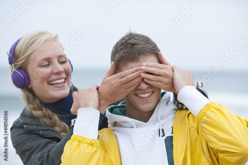 Photo: Young woman covering boyfriendճ eyes on beach Young woman covering boyfriendճ eyes on beach