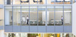 View of businessmen standing at opposite ends of conference room from outdoors