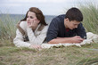 Photo: Teenage girl turning away from teenage boy text messaging on cell phone in grass on beach Teenage girl turning away from teenage boy text messaging on cell phone in grass on beach