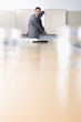 Portrait of smiling businessman opening cabinet in conference room