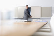 Portrait of smiling businessman opening cabinet in conference room