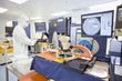 Engineer in clean suit working at computer in silicon wafer manufacturing laboratory