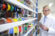 Photo: Engineer taking inventory of vibrant wire spools on digital tablet in laboratory Engineer taking inventory of vibrant wire spools on digital tablet in laboratory