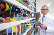 Photo: Engineer taking inventory of vibrant wire spools on digital tablet in laboratory Engineer taking inventory of vibrant wire spools on digital tablet in laboratory