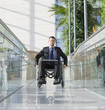 Businessman in wheelchair on pedestrian bridge