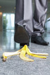 Businessman stepping on banana peel
