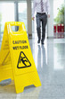 Businessman approaching wet floor sign on lobby floor
