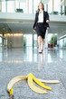 Businesswoman approaching banana peel on lobby floor
