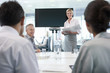 Businesswoman with folder leading meeting in conference room