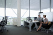 Businessman and businesswoman using digital tablet at desk in office